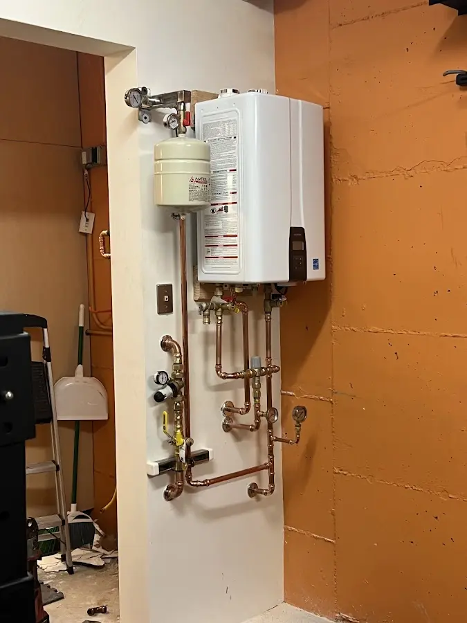 Plumbing technician inspecting water heater connections in Woodland Park